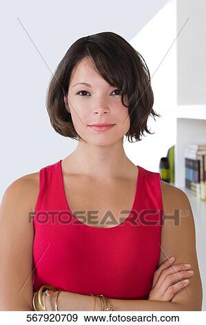 Portrait of a young woman with her arms crossed View Large Photo Image Stock Photo - Portrait of a young woman with her arms crossed. Fotosearch