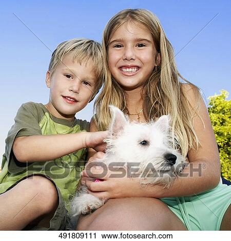 Portrait of two children carrying a dog and smiling View Large Photo Image Stock Image - Portrait of two children carrying a dog and smiling. Fotosearch