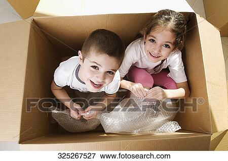 Portrait of two children sitting in a cardboard box and smiling View Large Photo Image Stock Photo - Portrait of two children sitting in a cardboard box and smiling. Fotosearch