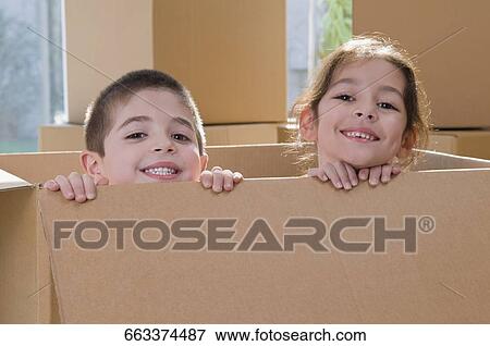 Portrait of two children smiling in a cardboard box View Large Photo Image Stock Photo - Portrait of two children smiling in a cardboard box. Fotosearch