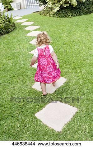 Rear view of a baby girl walking in a lawn View Large Photo Image Picture - Rear view of a baby girl walking in a lawn. Fotosearch