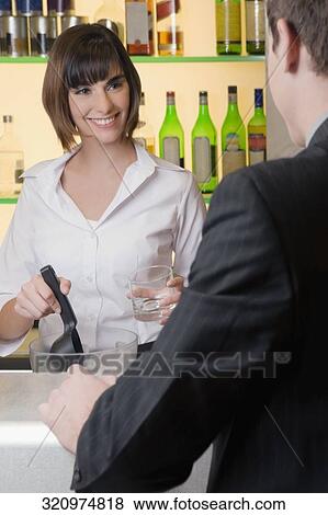Rear view of a businessman standing at a bar counter View Large Photo Image Stock Photo - Rear view of a businessman standing at a bar counter. Fotosearch