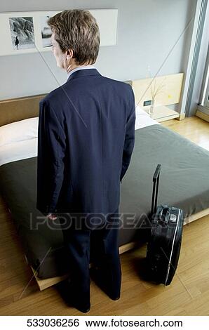 Rear view of a businessman standing in a hotel room View Large Photo Image Stock Photograph - Rear view of a businessman standing in a hotel room. Fotosearch