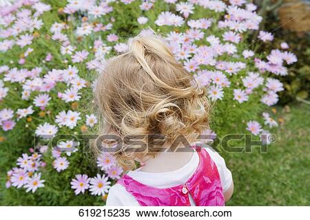 Rear view of a girl standing in a garden View Large Photo Image Stock Photography - Rear view of a girl standing in a garden. Fotosearch