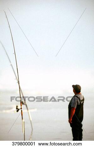 Rear view of a man standing on the beach and looking at view View Large Photo Image Stock Image - Rear view of a man standing on the beach and looking at view. Fotosearch