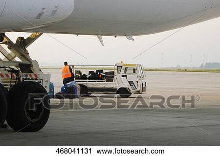 Stock Image - Rear view of a man unloading luggage from truck, Paris, Ile-de-France, France. Fotosearch