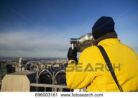 Rear view of a person looking through a coin-operated binocular, Manhattan, New York City, New York State, USA View Large Photo Image Stock Image - Rear view of a person looking through a coin-operated binocular, Manhattan, New York City, New York State, USA. Fotosearch