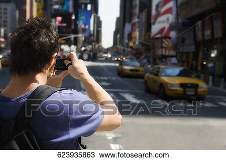 Rear view of a tourist photographing, Times Square, Manhattan, New York City, New York State, USA View Large Photo Image Stock Image - Rear view of a tourist photographing, Times Square, Manhattan, New York City, New York State, USA. Fotosearch