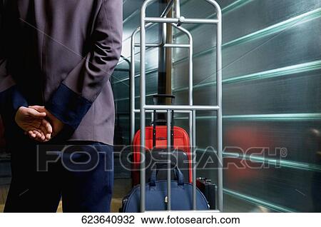 Rear view of a waiter standing near a luggage rack View Large Photo Image Stock Image - Rear view of a waiter standing near a luggage rack. Fotosearch