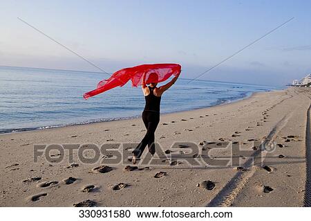 Rear view of a woman running on the beach and carrying a stole View Large Photo Image Stock Image - Rear view of a woman running on the beach and carrying a stole. Fotosearch