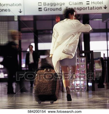 Rear view of a woman walking at an airport View Large Photo Image Picture - Rear view of a woman walking at an airport. Fotosearch