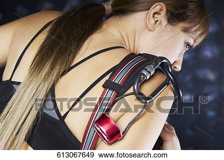 Rear view of a young woman preparing for rock climbing View Large Photo Image Stock Photo - Rear view of a young woman preparing for rock climbing. Fotosearch