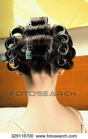 Rear view of a young woman wearing hair rollers View Large Photo Image Stock Image - Rear view of a young woman wearing hair rollers. Fotosearch