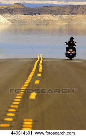 Stock Image - Rear view of two people on a motorcycle near the sea, Las Vegas, Nevada, USA. Fotosearch