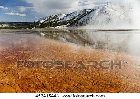 Stock Image - Reflection of a mountain in a hot spring, Grand Prismatic Spring, Yellowstone National park, Wyoming, USA. Fotosearch