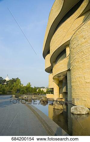 Picture - Reflection of a national museum in water, National Museum of the American Indian, The Mall, Washington DC, USA. Fotosearch