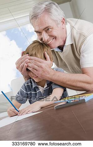Senior man covering eyes of his grandson and smiling View Large Photo Image Stock Image - Senior man covering eyes of his grandson and smiling. Fotosearch