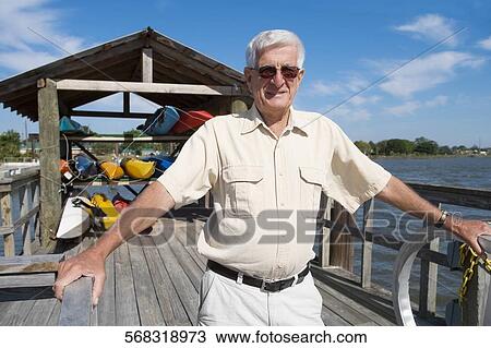 Senior man standing on a pier View Large Photo Image Stock Image - Senior man standing on a pier. Fotosearch