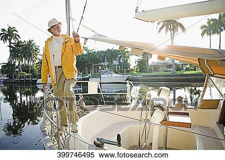 Senior man standing on the ship's bow and thinking View Large Photo Image Stock Photography - Senior man standing on the ship's bow and thinking. Fotosearch
