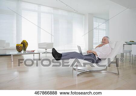 Senior man using a laptop and smiling View Large Photo Image Stock Photo - Senior man using a laptop and smiling. Fotosearch