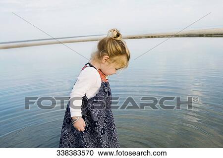 Side profile of a baby girl standing in water View Large Photo Image Stock Image - Side profile of a baby girl standing in water. Fotosearch