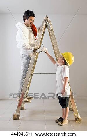 Side profile of a boy assisting his father View Large Photo Image Stock Image - Side profile of a boy assisting his father. Fotosearch