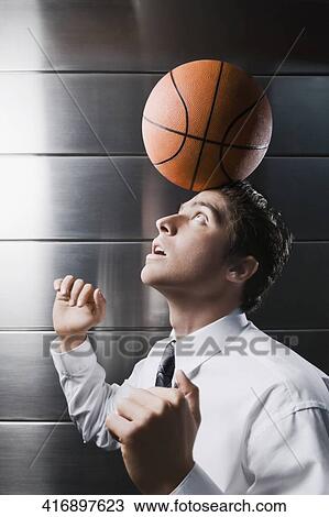 Side profile of a businessman balancing a basketball on his forehead View Large Photo Image Stock Image - Side profile of a businessman balancing a basketball on his forehead. Fotosearch