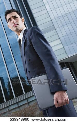 Side profile of a businessman holding a laptop View Large Photo Image Stock Image - Side profile of a businessman holding a laptop. Fotosearch