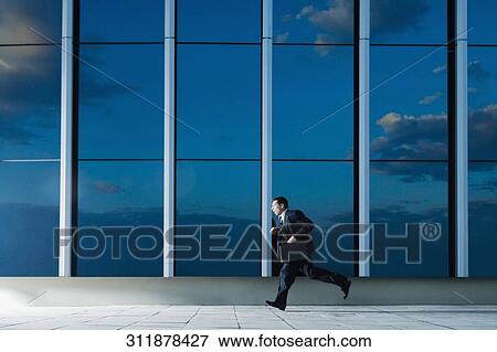 Side profile of a businessman running with a briefcase View Large Photo Image Stock Photo - Side profile of a businessman running with a briefcase. Fotosearch