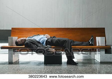 Side profile of a businessman sleeping on a bench View Large Photo Image Stock Image - Side profile of a businessman sleeping on a bench. Fotosearch