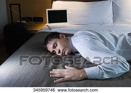 Side profile of a businessman sleeping on the bed View Large Photo Image Stock Photograph - Side profile of a businessman sleeping on the bed. Fotosearch