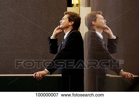 Side profile of a businessman talking on a mobile phone and smiling View Large Photo Image Stock Photo - Side profile of a businessman talking on a mobile phone and smiling. Fotosearch