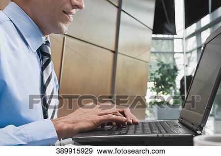 Side profile of a businessman using a laptop View Large Photo Image Stock Photo - Side profile of a businessman using a laptop. Fotosearch
