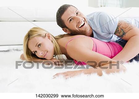 Side profile of a couple romancing on rug View Large Photo Image Stock Photo - Side profile of a couple romancing on rug. Fotosearch