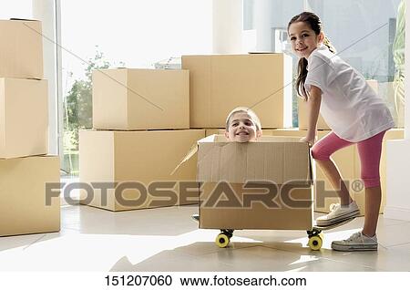Side profile of a girl pushing a cardboard box with her brother View Large Photo Image Stock Image - Side profile of a girl pushing a cardboard box with her brother. Fotosearch