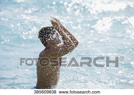 Side profile of a man splashing water View Large Photo Image Stock Photo - Side profile of a man splashing water. Fotosearch
