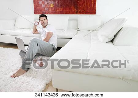 Side profile of a mid adult man holding a credit card and using a laptop View Large Photo Image Stock Photograph - Side profile of a mid adult man holding a credit card and using a laptop. Fotosearch