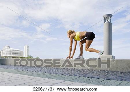 Side profile of a mid adult woman in a running position on the ledge View Large Photo Image Stock Photo - Side profile of a mid adult woman in a running position on the ledge. Fotosearch