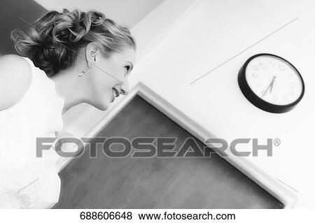 Side profile of a mid adult woman looking at a clock and smiling View Large Photo Image Stock Photo - Side profile of a mid adult woman looking at a clock and smiling. Fotosearch