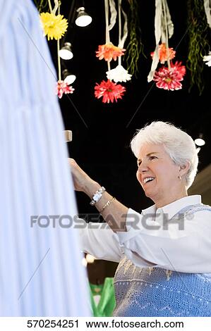 Side profile of a senior woman smiling in a store View Large Photo Image Stock Image - Side profile of a senior woman smiling in a store. Fotosearch