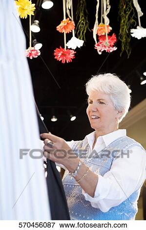 Side profile of a senior woman standing in a store View Large Photo Image Stock Photo - Side profile of a senior woman standing in a store. Fotosearch