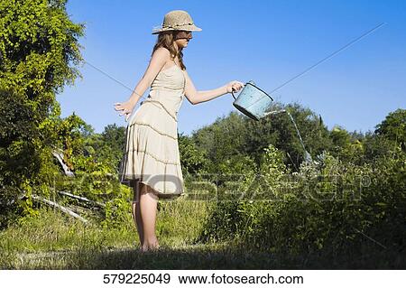Side profile of a teenage girl watering plants View Large Photo Image Stock Photo - Side profile of a teenage girl watering plants. Fotosearch