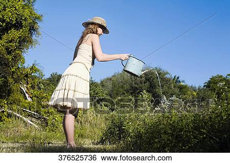 Side profile of a teenage girl watering plants View Large Photo Image Stock Photograph - Side profile of a teenage girl watering plants. Fotosearch
