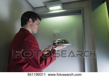 Side profile of a waiter holding a domed tray View Large Photo Image Stock Image - Side profile of a waiter holding a domed tray. Fotosearch
