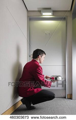 Side profile of a waiter squatting and holding a domed tray View Large Photo Image Stock Image - Side profile of a waiter squatting and holding a domed tray. Fotosearch