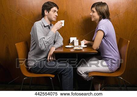 Side profile of a young couple having coffee in a cafe View Large Photo Image Stock Photography - Side profile of a young couple having coffee in a cafe. Fotosearch