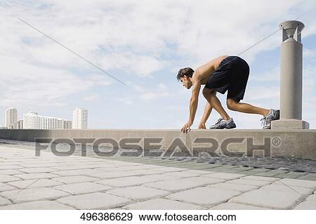 Side profile of a young man in running position on the ledge View Large Photo Image Stock Photo - Side profile of a young man in running position on the ledge. Fotosearch