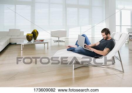 Side profile of a young man using a laptop and smiling View Large Photo Image Stock Image - Side profile of a young man using a laptop and smiling. Fotosearch