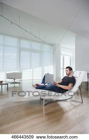 Side profile of a young man using a laptop View Large Photo Image Stock Photo - Side profile of a young man using a laptop. Fotosearch