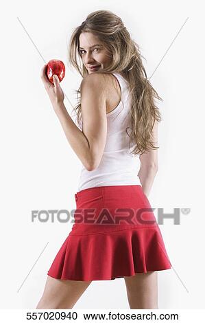 Side profile of a young woman holding an apple View Large Photo Image Stock Image - Side profile of a young woman holding an apple. Fotosearch